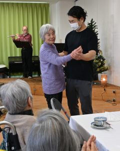 フルートとピアノの演奏にあわせてダンスする2人の写真。クリスマス喫茶の一幕。特別養護老人ホームせとうちは岡山県瀬戸内の老人ホームです。