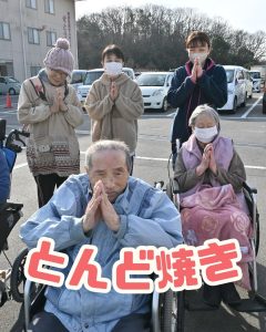 とんど焼きの火を拝むご利用者様の写真。特別養護老人ホームせとうちにて。